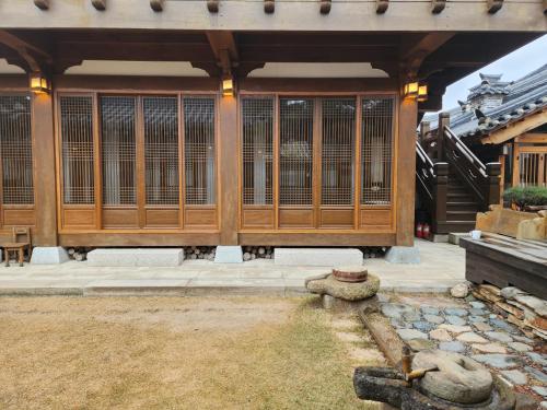 a building with wooden doors and a pond at HanokInn in Gyeongju