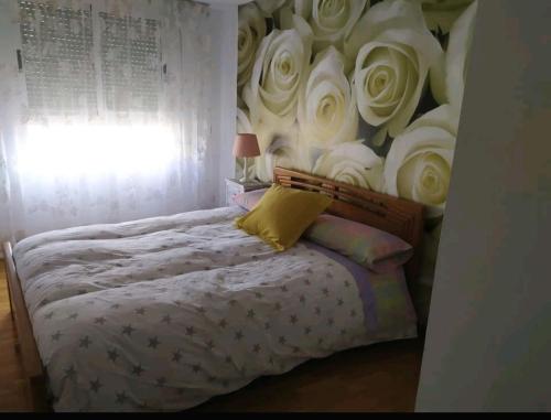 a bedroom with a bed with a wall of white roses at Precioso apartamento a 7 minutos en tren al centro de Valencia in Benetúser