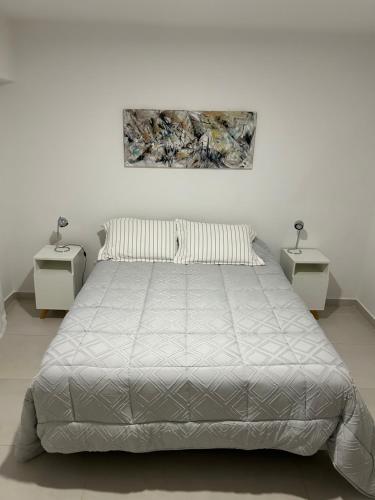 - une chambre blanche avec un lit et 2 tables de chevet dans l'établissement Reconquista900, à Buenos Aires