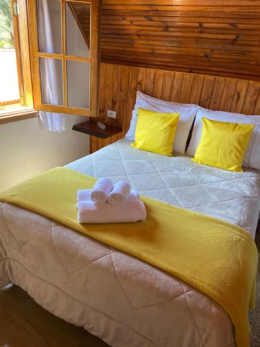 a bedroom with a bed with two towels on it at Chales Boa Vista in Monte Verde