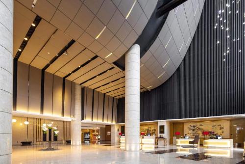 a lobby of a building with a large ceiling at Enlux Hotel in Jinan