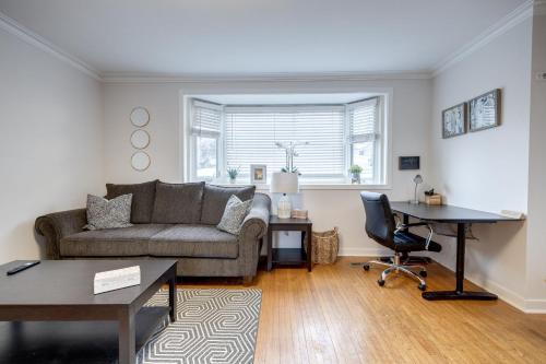 a living room with a couch and a desk at Eglinton West Guest Suite in Toronto