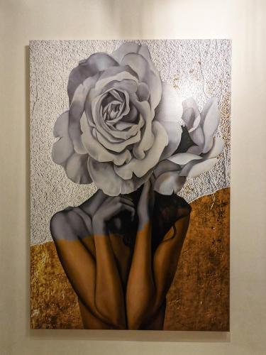 una pintura de una mujer sosteniendo una flor en Soho West End, en Londres