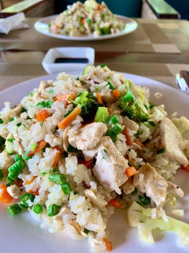 a plate of rice with chicken and vegetables on a table at Rainbow Lodge in Koh Kong