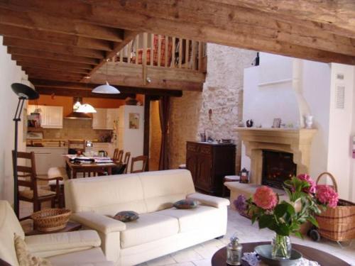 un salon avec un canapé blanc et une cheminée dans l'établissement Ancienne ferme restaurée avec charme, vergers de mirabelles, borne électrique, proche Lac de Madine - FR-1-585-7, à Buxières-sous-les-Côtes