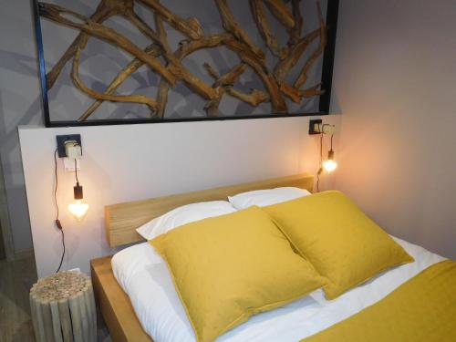 1 dormitorio con 1 cama con manta amarilla y luces en Gîte Laville-aux-Bois, 2 pièces, 2 personnes - FR-1-611-70, en Laville-aux-Bois