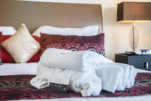 a pile of towels sitting on top of a bed at Monaco Caloundra in Caloundra