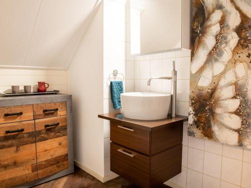 a bathroom with a sink on a wooden counter at Rustic farm house in the middle of the Achterhoek in Steenderen