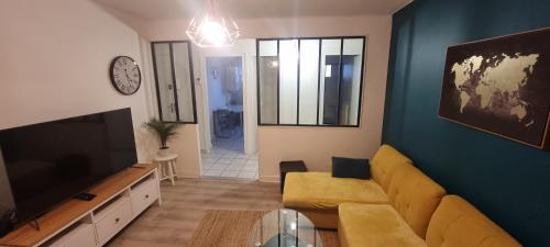 a living room with a couch and a flat screen tv at T3 cosy, calme & lumineux proche Eurexpo, Groupama in Saint-Priest