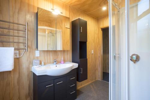 a bathroom with a sink and a shower at Fox Glacier TOP 10 Holiday Park & Motels in Fox Glacier