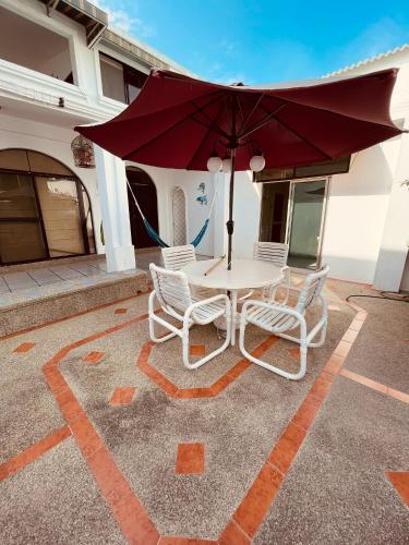 a table with chairs and an umbrella on a patio at Casa en Punta Barandua Playa Privada in Santa Elena