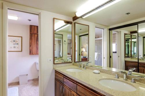 La salle de bains est pourvue de 2 lavabos et de 2 miroirs. dans l'établissement Tina's Waikiki Beach Tower, à Honolulu
