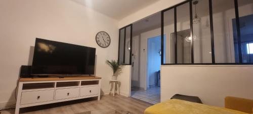 a living room with a flat screen television on a dresser at T3 cosy, calme & lumineux proche Eurexpo, Groupama in Saint-Priest
