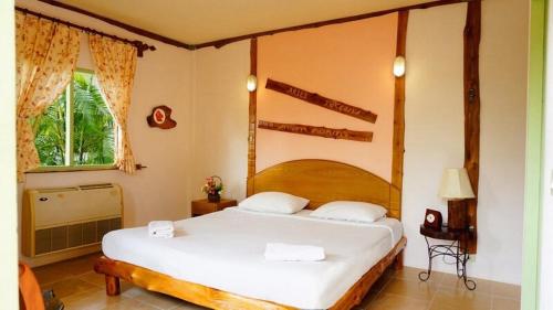 a bedroom with a large white bed in a room at Sanita Cottage in Chom Bung