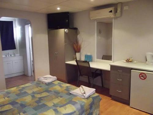 eine Küche mit einem Bett und einem Schreibtisch in einem Zimmer in der Unterkunft Leo Hotel Motel in Clermont