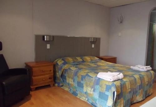 ein Schlafzimmer mit einem Bett mit zwei Handtüchern darauf in der Unterkunft Leo Hotel Motel in Clermont