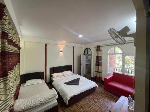 a bedroom with a bed and a red couch at Hello KTM Hostel in Kathmandu