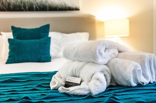 a pile of towels sitting on top of a bed at Monaco Caloundra in Caloundra