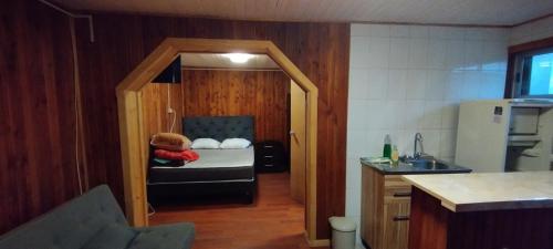een kleine keuken met een klein bed in een kamer bij JANICO CABAÑAS in Loncoche