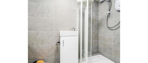 a shower with a glass door in a bathroom at Cosy Little Flat - Perfect Base for Explorers in London