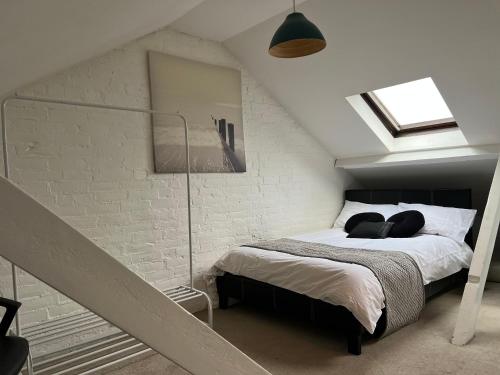 a bedroom with a bed in a attic at Chart Cottage in Stanmore