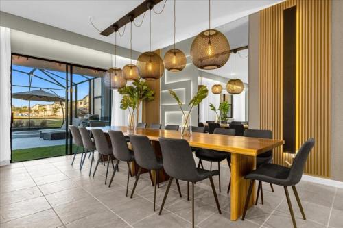 a dining room with a wooden table and chairs at 12 Bedrooms- 11,5 Baths- Paradiso Grande 10000vw in Orlando