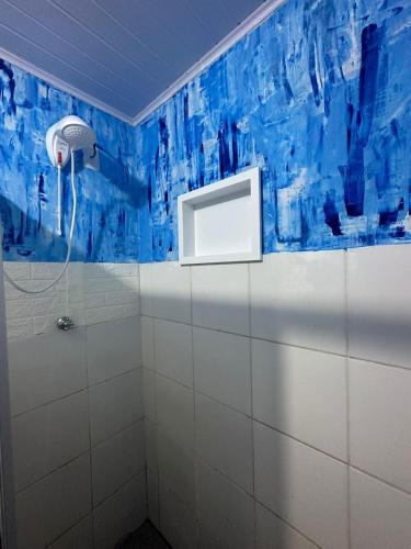 y baño con ducha y pared azul. en Casa sambaqui, en Florianópolis