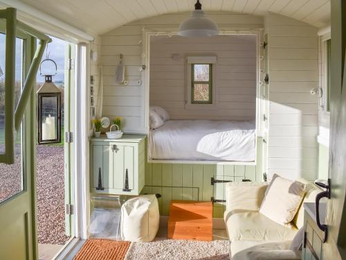 モンマスにあるThe Little Lodgeのベッド1台とソファが備わる小さな客室です。