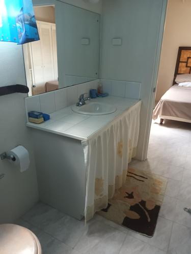 uma casa de banho com um lavatório e um espelho em Super breezy cozynook ! em Bridgetown