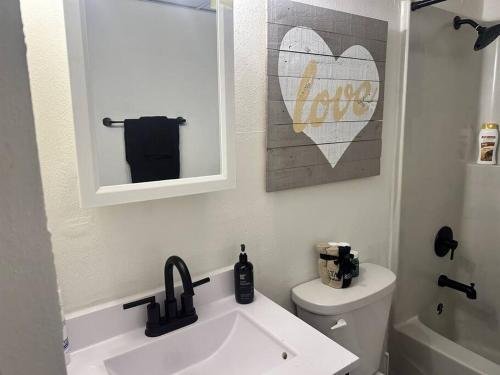 a bathroom with a sink and a toilet and a mirror at Old Aristocracy Hill 1BR Quiet Apartment Downtown! in Springfield
