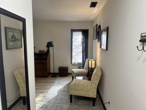 ein Wohnzimmer mit einem Stuhl und einem Tisch in der Unterkunft Old Aristocracy Hill 1BR Quiet Apartment Downtown! in Springfield