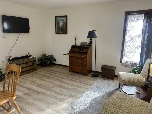 a living room with a tv and a wooden floor at Old Aristocracy Hill 1BR Quiet Apartment Downtown! in Springfield