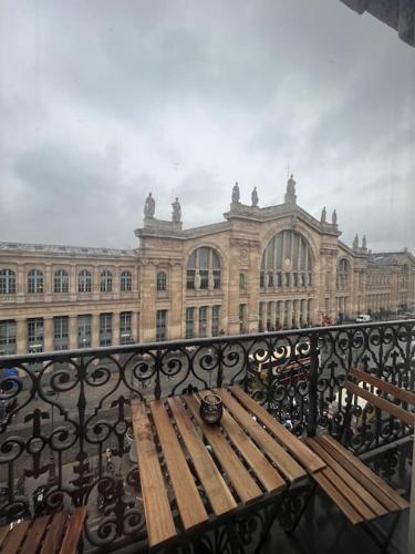 - un banc en bois sur un balcon en face d'un bâtiment dans l'établissement Central Parisian Apartment, à Paris