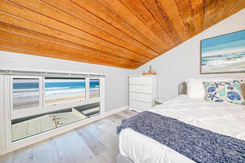 a bedroom with a bed and a view of the beach at Stunning Ocean Views - Recently Renovated Home & Warm Sunsets in San Diego