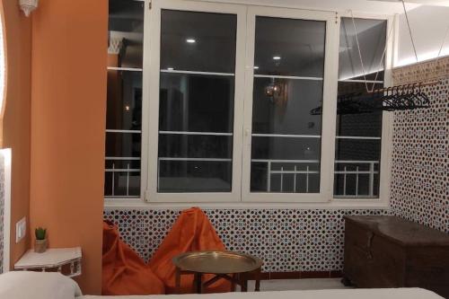 a room with a window and a table and a stool at Al-Andalus hause a 9min. del centro en metro in San Juan de Aznalfarache
