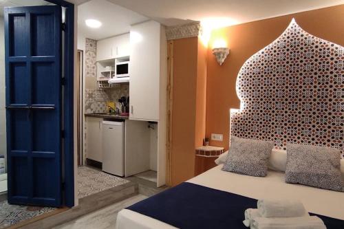 a bedroom with a bed with a large headboard at Al-Andalus hause a 9min. del centro en metro in San Juan de Aznalfarache