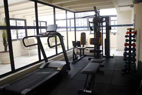 a gym with cardio equipment in a room with windows at Cyclinn Bela Cintra Jardins in Sao Paulo