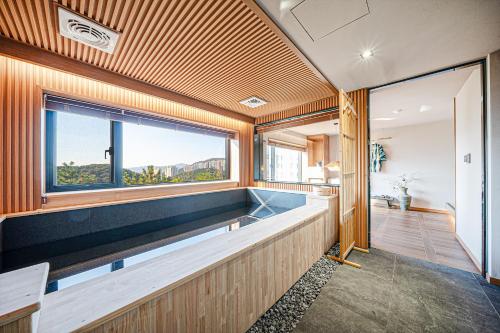 a swimming pool in a house with a large window at Mandeok Denbasta Ryokan in Busan