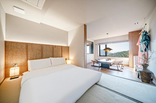 a bedroom with a large bed and a table at Mandeok Denbasta Ryokan in Busan