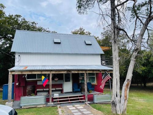 a red and white house with an american flag at Bastrop Tiny Disc Golf Retreat in Bastrop