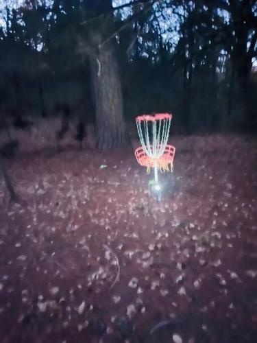 a red frisbee golf basket in a park at Bastrop Tiny Disc Golf Retreat in Bastrop