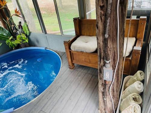 a blue tub in a room with a tree at Bastrop Tiny Disc Golf Retreat in Bastrop