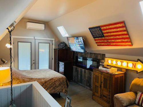 una camera da letto con un letto e una bandiera americana sul muro di Bastrop Tiny Disc Golf Retreat a Bastrop