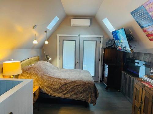 ein Schlafzimmer mit einem Bett und einem TV. in der Unterkunft Bastrop Tiny Disc Golf Retreat in Bastrop