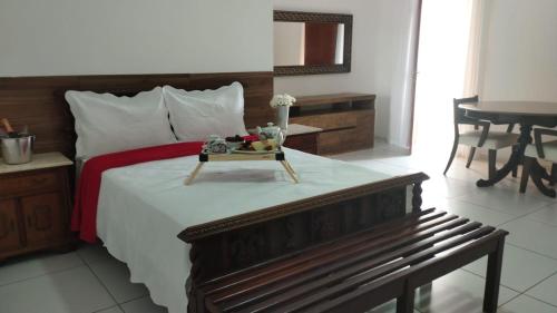 a bedroom with a bed with a tray of fruit on it at Fazendinha Parque Raposa in Iguaíba