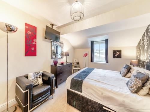 a bedroom with a large bed and a chair at Durham Oasis Apartment - Uk46017 in Durham