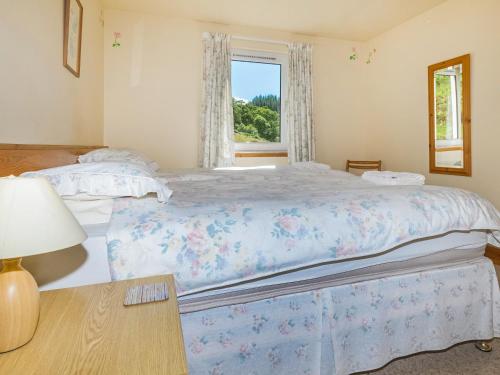 Un dormitorio con una cama grande y una ventana en The Barn, en Dalmally
