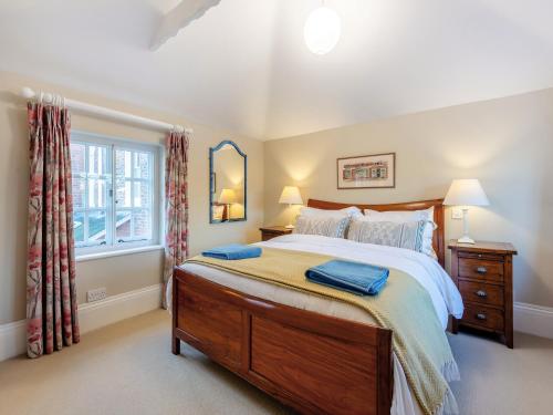 - une chambre avec un grand lit et une fenêtre dans l'établissement The Stables, à Crockham Hill