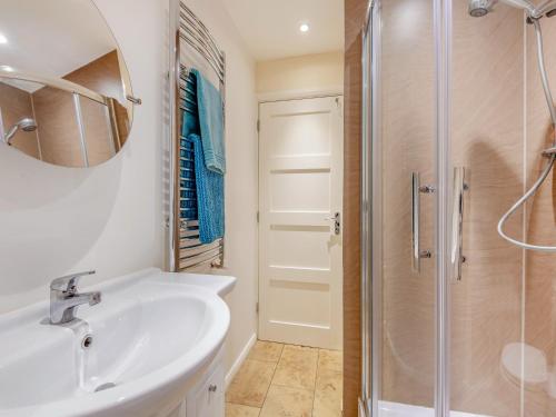 La salle de bains est pourvue d'un lavabo et d'une douche. dans l'établissement The Stables, à Crockham Hill
