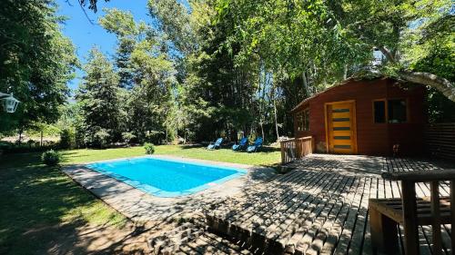a tiny house with a pool in the yard at Cabaña Roca Volcán in Melipeuco